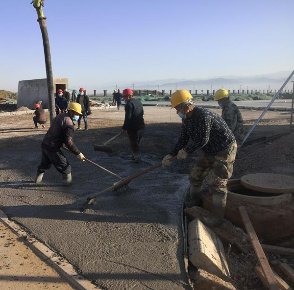 寶雞蟠龍新區(qū)污水處理廠項目施工人員對廠區(qū)道路面層進行混凝土澆筑作業(yè)_副本.jpg
